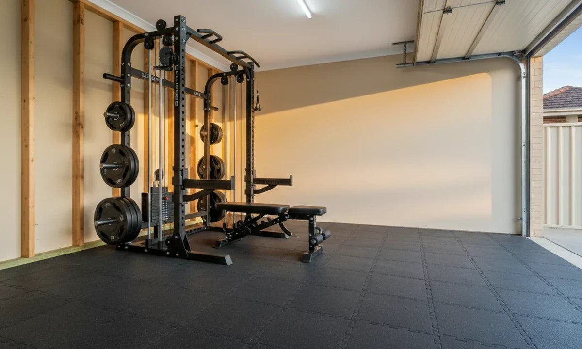Australian suburban home garage with an all-in-one power rack, Smith machine and cable stacks lit by late-afternoon sunlight