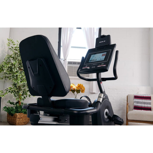 Woman exercising on a recumbent bike in a modern home gym setting