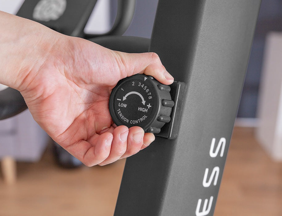 User adjusting the tension control knob on the Lifespan Fitness Corsair FreeRun 105 Curved Treadmill, featuring customizable resistance for an enhanced workout experience.