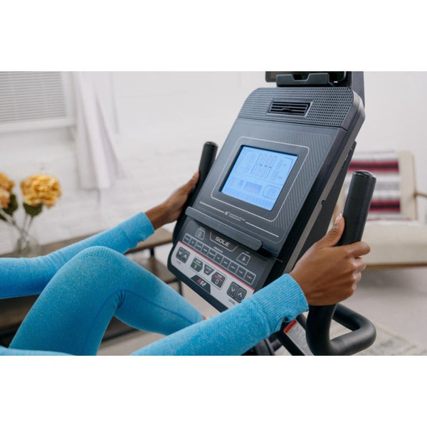 Woman exercising on a Sole R92 recumbent bike in a bright, modern room