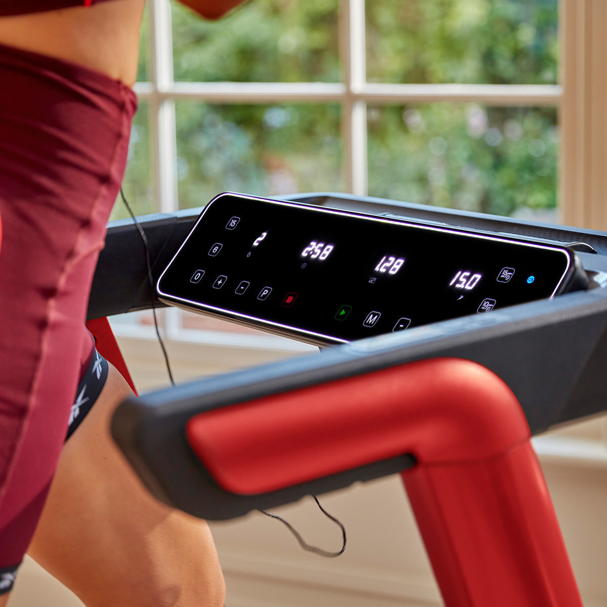 Tablet holder on fitness equipment displaying workout video for exercise enthusiasts