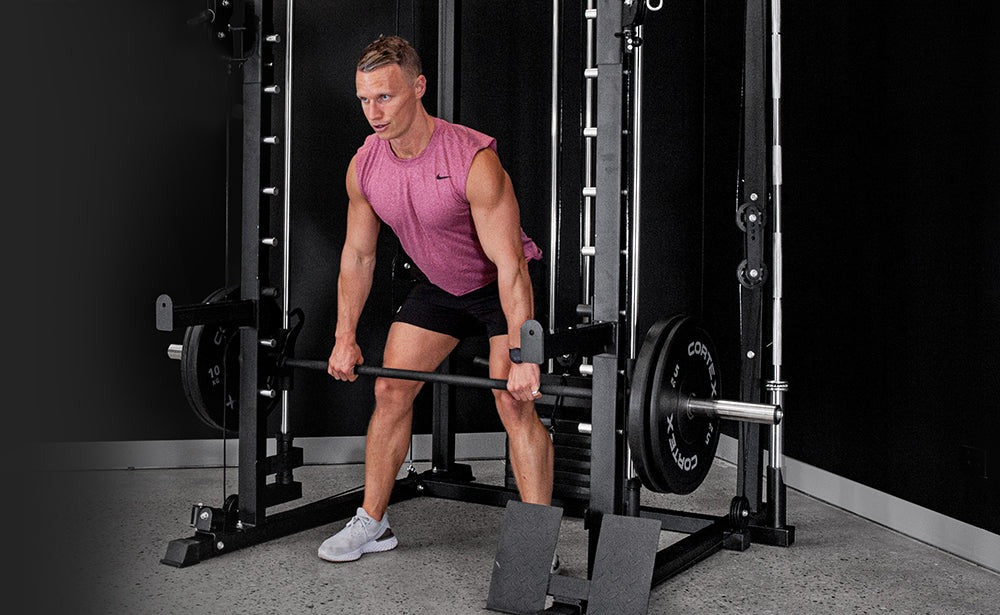 CORTEX SM-20 6-in-1 Power Rack with Smith & Cable Machine featuring a person performing pull-ups. Ideal for strength training and home gyms, this versatile equipment combines multiple workout options for effective fitness routines.