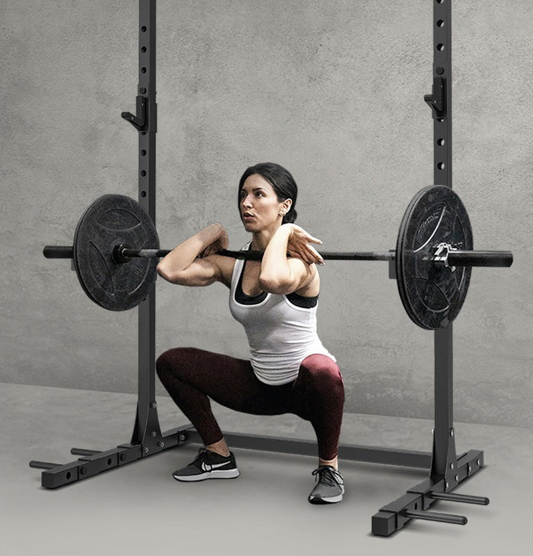 Adjustable squat rack with weight plates and safety bars for home gym workouts