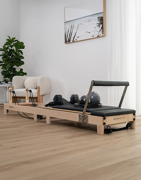 Lifespan Fitness Contour 2 Folding Wood Pilates Reformer with adjustable resistance straps and padded black cushions for a comfortable workout experience.