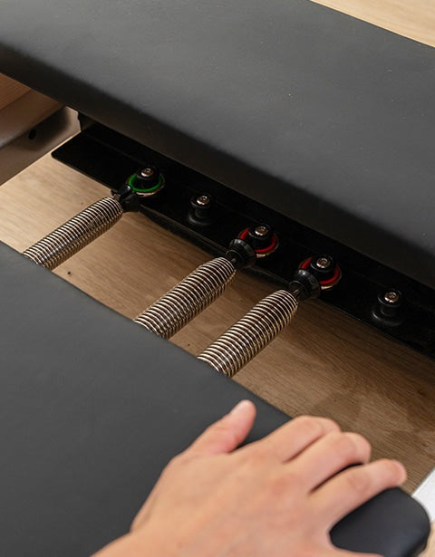 Lifespan Fitness Contour 2 Folding Wood Pilates Reformer with padded black platform and spring resistance system, designed for at-home Pilates workouts and fitness enthusiasts.