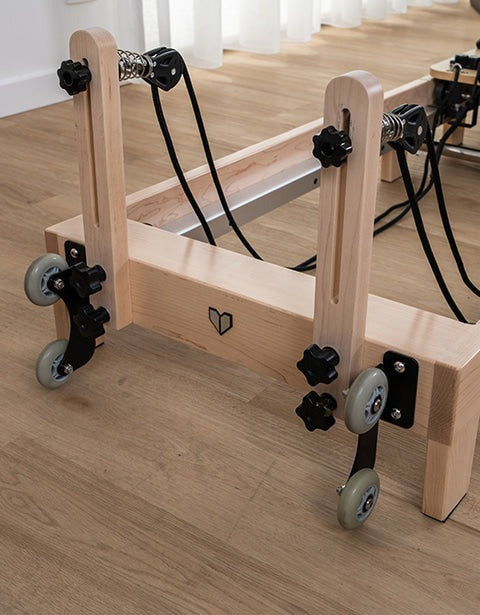 Lifespan Fitness Contour 2 Folding Wood Pilates Reformer featuring a sturdy wooden frame, adjustable resistance springs, and smooth-rolling wheels for easy portability and storage.
