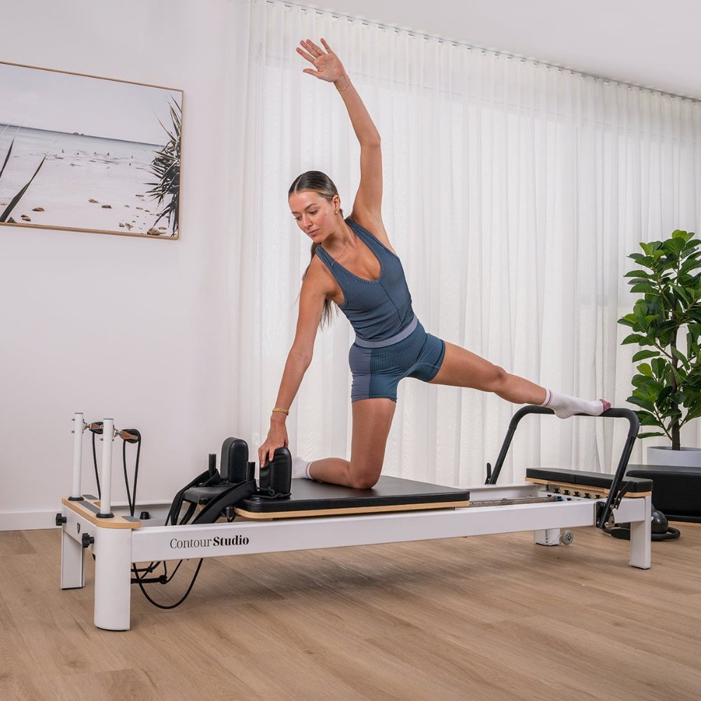 Lifespan Fitness Contour Studio Commercial Pilates Reformer Bed Set featuring a sturdy white frame, adjustable resistance springs, and a cushioned black platform for Pilates workouts.