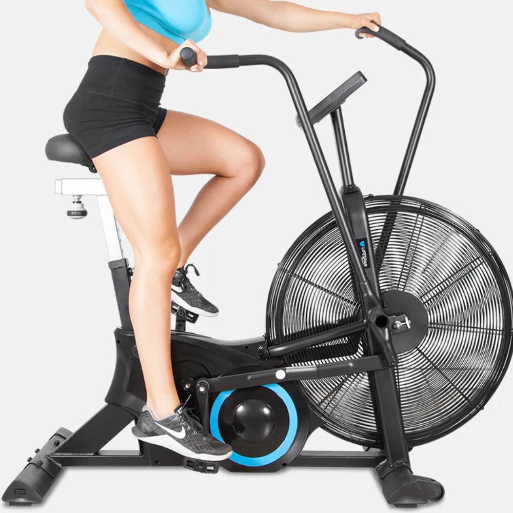 User exercising on a stationary air bike for cardio fitness training