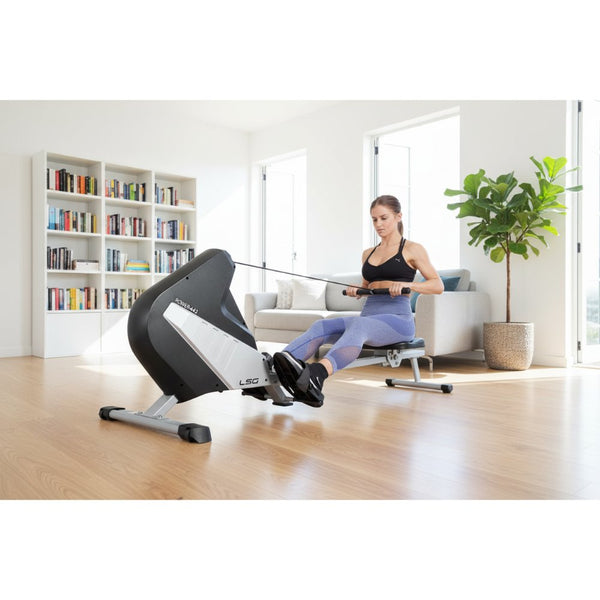 Woman using a rowing machine for a full-body workout in stylish activewear.