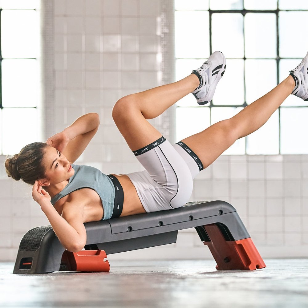 Man performing bent-over dumbbell row on an adjustable workout bench
