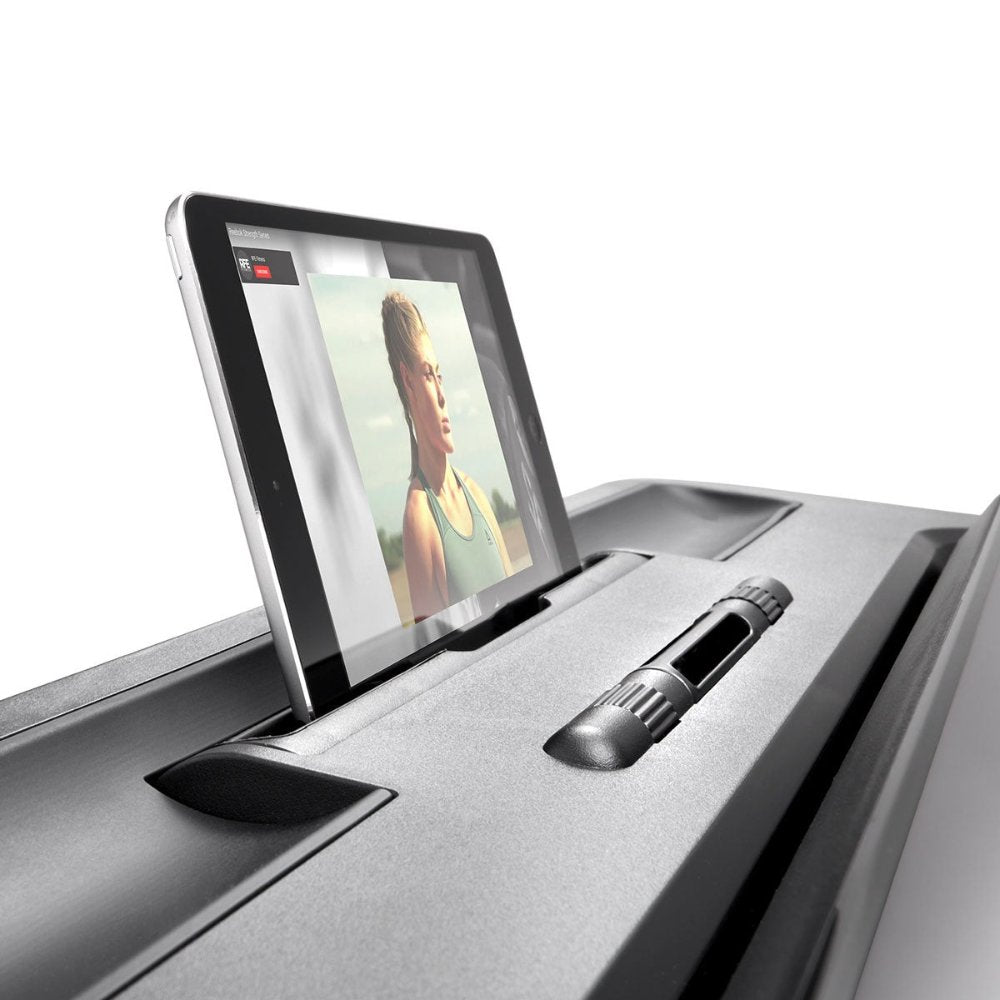 Woman exercising on a sleek FLOATRIDE+ treadmill in a bright, modern living room.