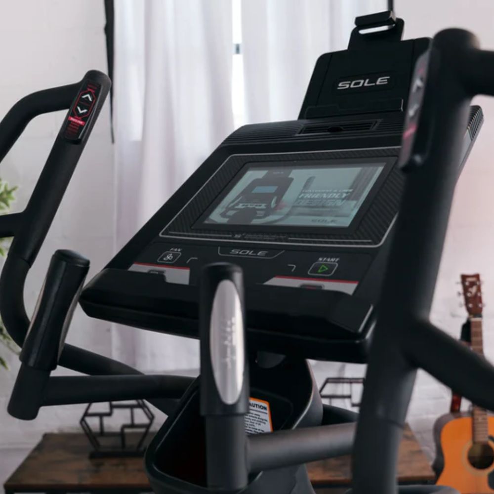 Woman exercising on a sleek elliptical machine in a modern home gym setting.