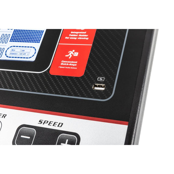 Modern treadmill in a stylish home gym with a young woman checking her phone