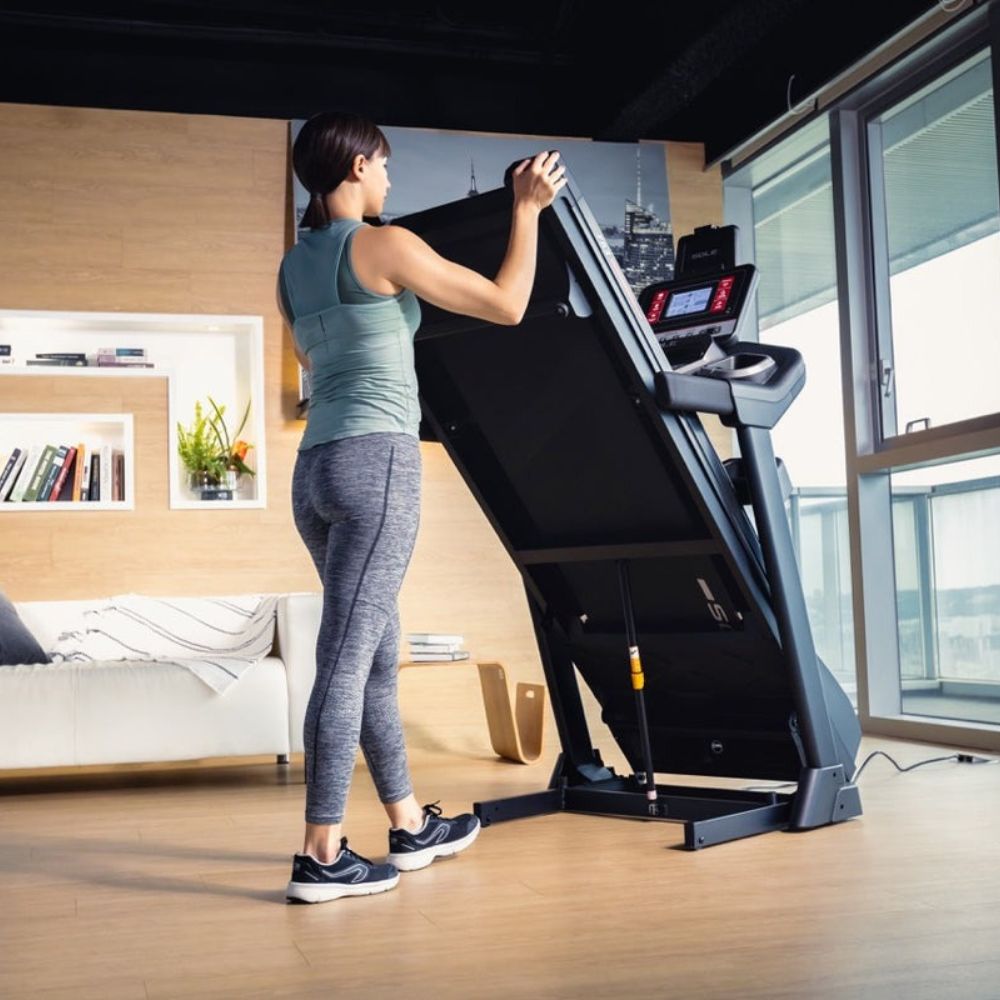 User adjusting the speed setting on a modern treadmill control panel.