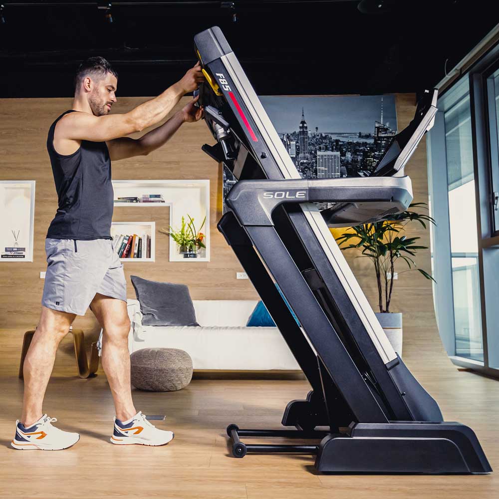 sole f85 treadmill folded with man standing