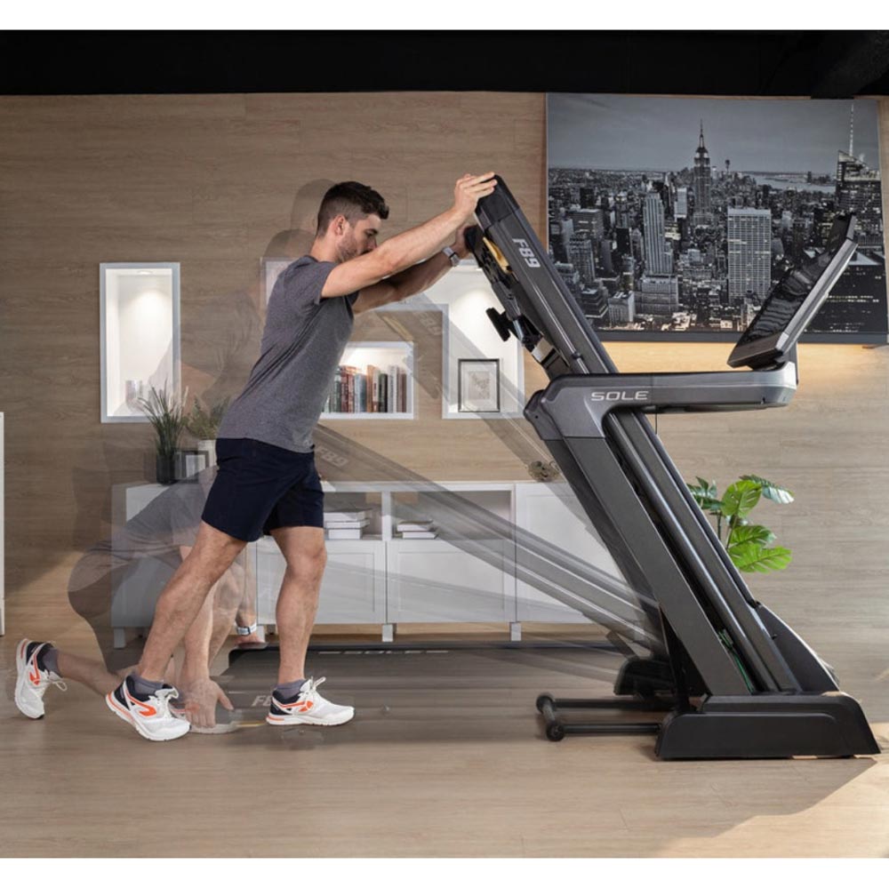 Man exercising on a Sole treadmill in a modern home gym setup