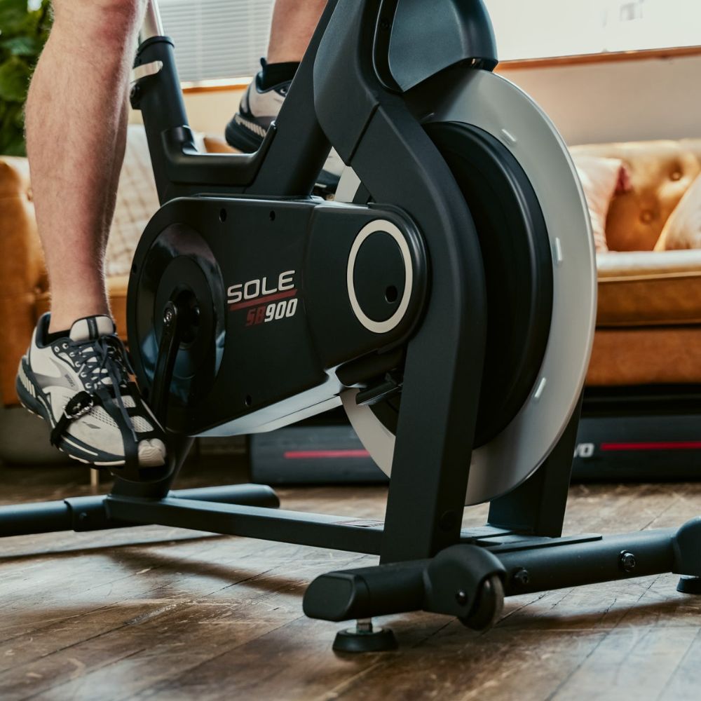 Sole SB900 indoor cycling bike with fitness enthusiast in home gym setting