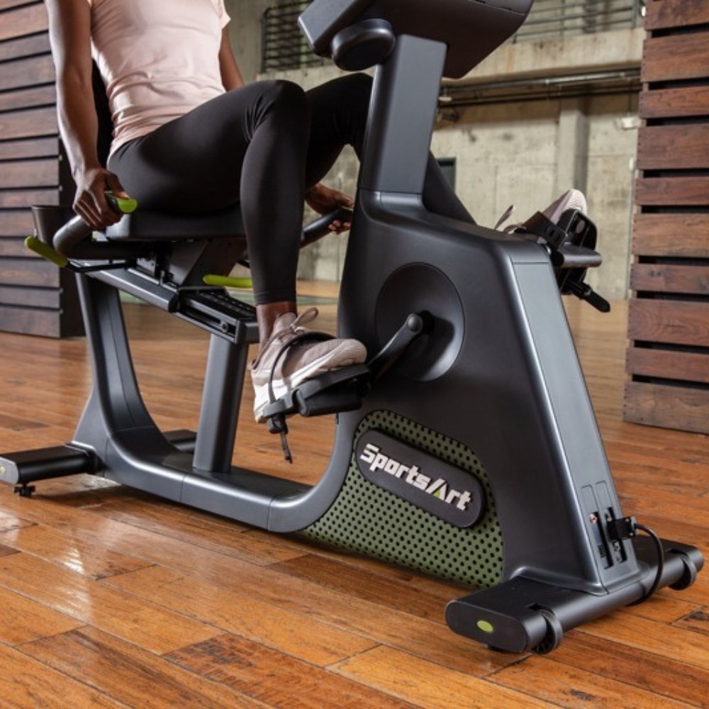 Woman exercising on a SportArt recumbent bike in a modern gym setting