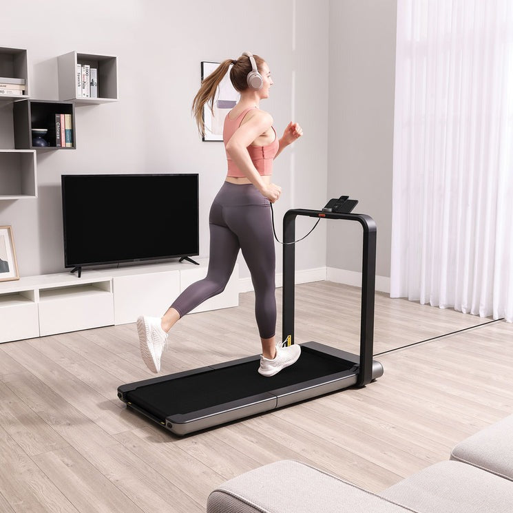 Home treadmill with a woman exercising indoors in stylish fitness attire