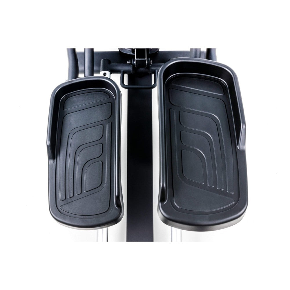 Sole elliptical machine in a bright room with plants, ideal for home workouts.